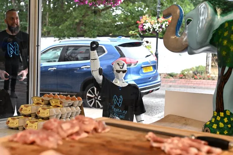 Jimmy raising a fist in the window of Ascot Butchers, seen from inside the shop